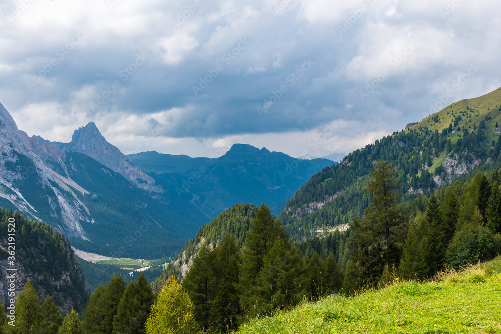 Obraz premium Majestic Dolomites under a very bright sky and with green forests at the bottom