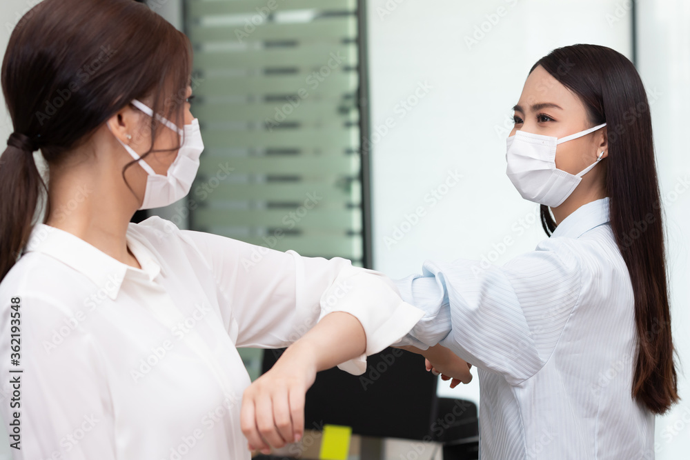 business woman wering mask use elbow hello instead of hand shake. business woman wering mask use elbow hello instead of hand shake.