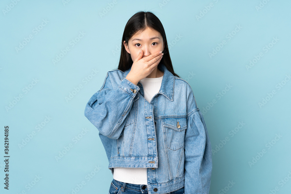 Young asian woman isolated on background covering mouth with hand Young asian woman isolated on background covering mouth with hand