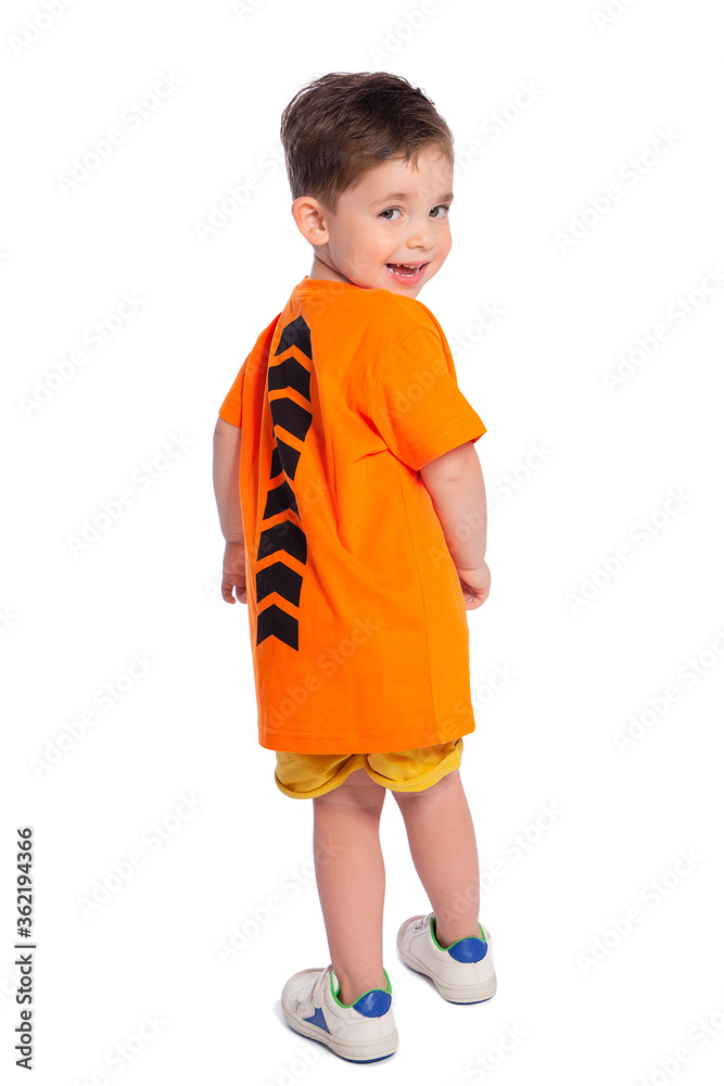 Portrait of a beautiful European boy 2 years old in full growth, rear view. A beautiful and happy child. A child's smile. Isolated on a white background in an orange t-shirt. Portrait of a beautiful European boy 2 years old in full growth, rear view. A beautiful and happy child. A child's smile. Isolated on a white background in an orange t-shirt.
