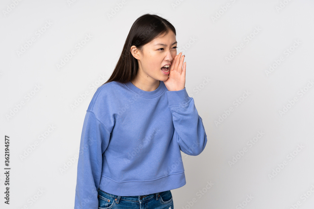 Young asian woman isolated on background shouting with mouth wide open to the side Young asian woman isolated on background shouting with mouth wide open to the side