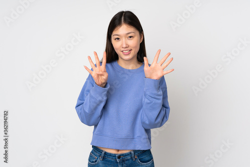 Young asian woman isolated on background counting nine with fingers