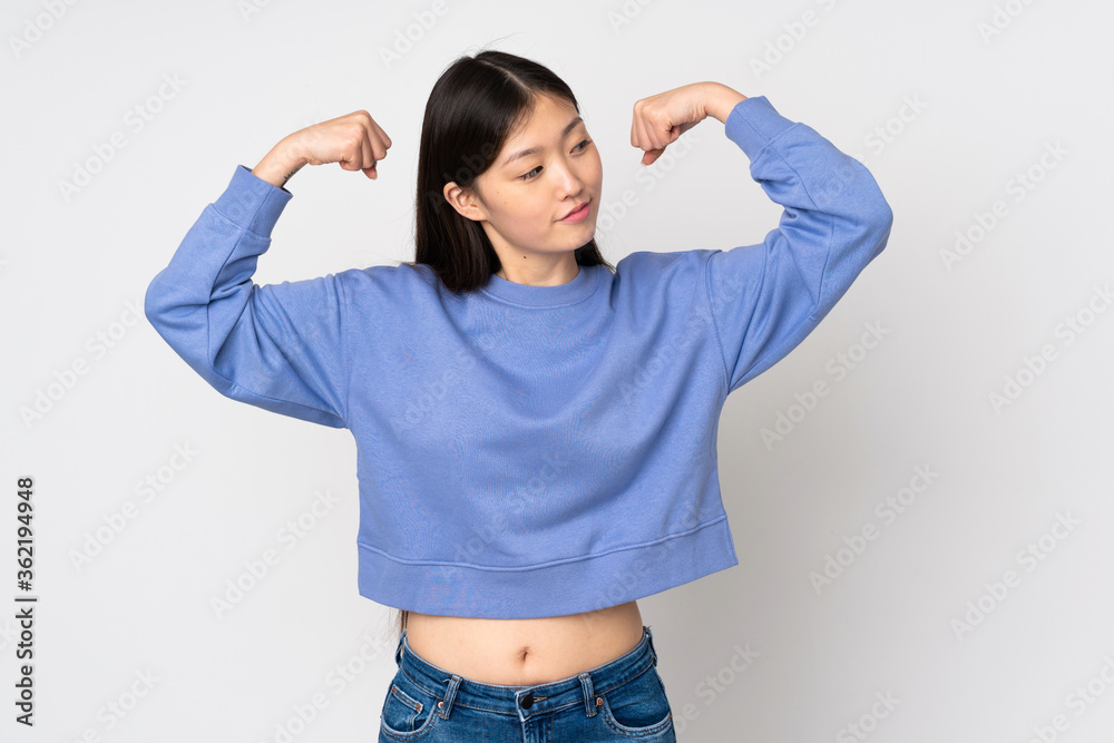 Young asian woman isolated on background doing strong gesture Young asian woman isolated on background doing strong gesture