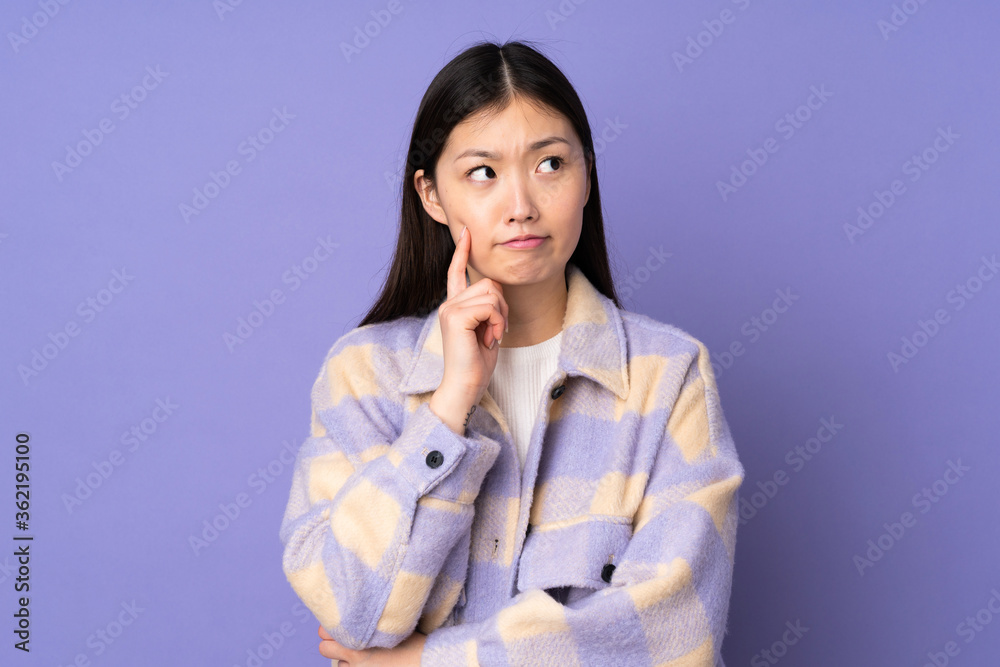 Young asian woman isolated on purple background having doubts and thinking Young asian woman isolated on purple background having doubts and thinking