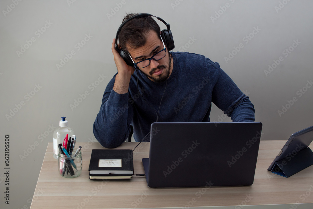 Caucasian man working from home with his cell phone and tablet Caucasian man working from home with his cell phone and tablet