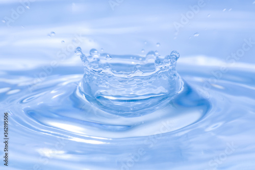 close up water crown, sparks of blue water on a white background