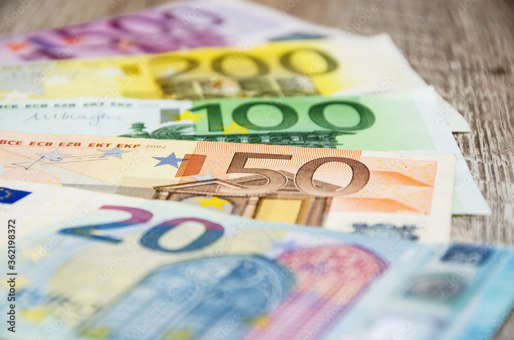 Euro banknotes with different denomination on a wooden background. Close-up. Financial concept. Euro banknotes with different denomination on a wooden background. Close-up. Financial concept.