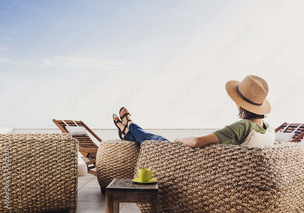 Young woman reslaxing on terrace at home. Beautiful girl enjoying life. Vacations, relaxation and summer fun concept - obrazy, fototapety, plakaty 