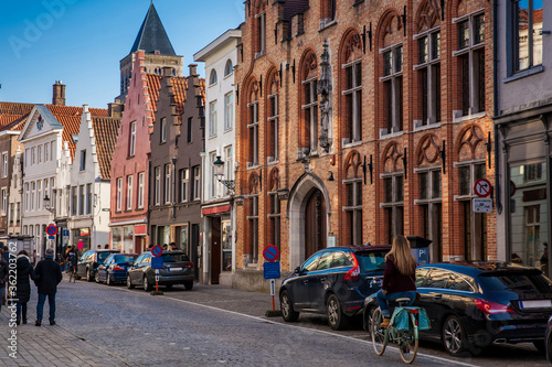 Fototapeta Naklejka Na Ścianę i Meble -  Young woman biker at the beautiful streets of the historical town of Bruges