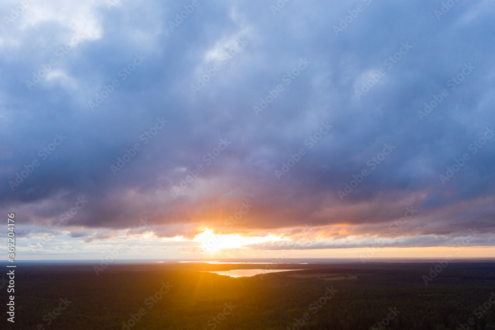 Aerial view sunset over the forest and lake. Top view. View from drone. Aerial top view cloudscape. Texture of clouds. View from above. Sunrise or sunset over clouds