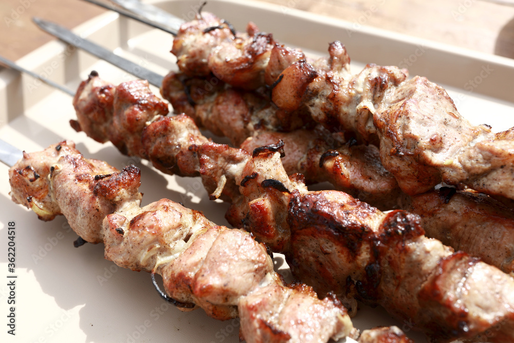 Tray with cooked pork neck on skewers