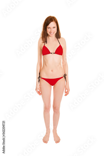 Portrait of a barefoot young woman wearing a red bikini, isolated on white studio background