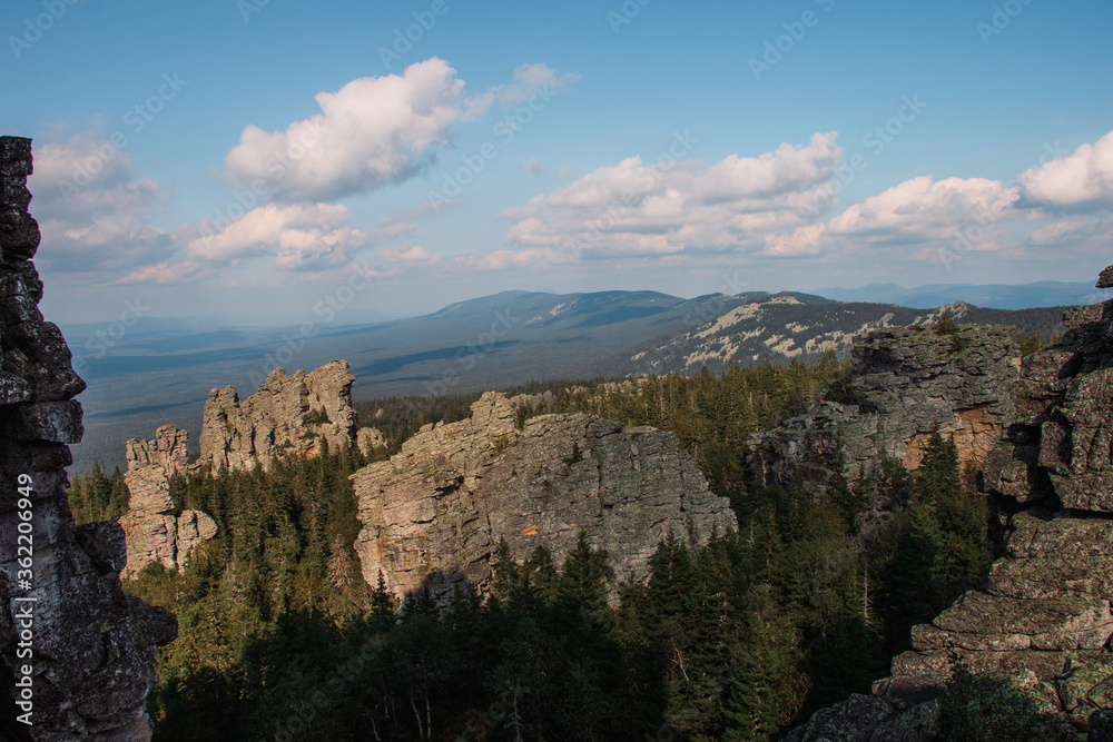 clouds over coniferous forest and rocks