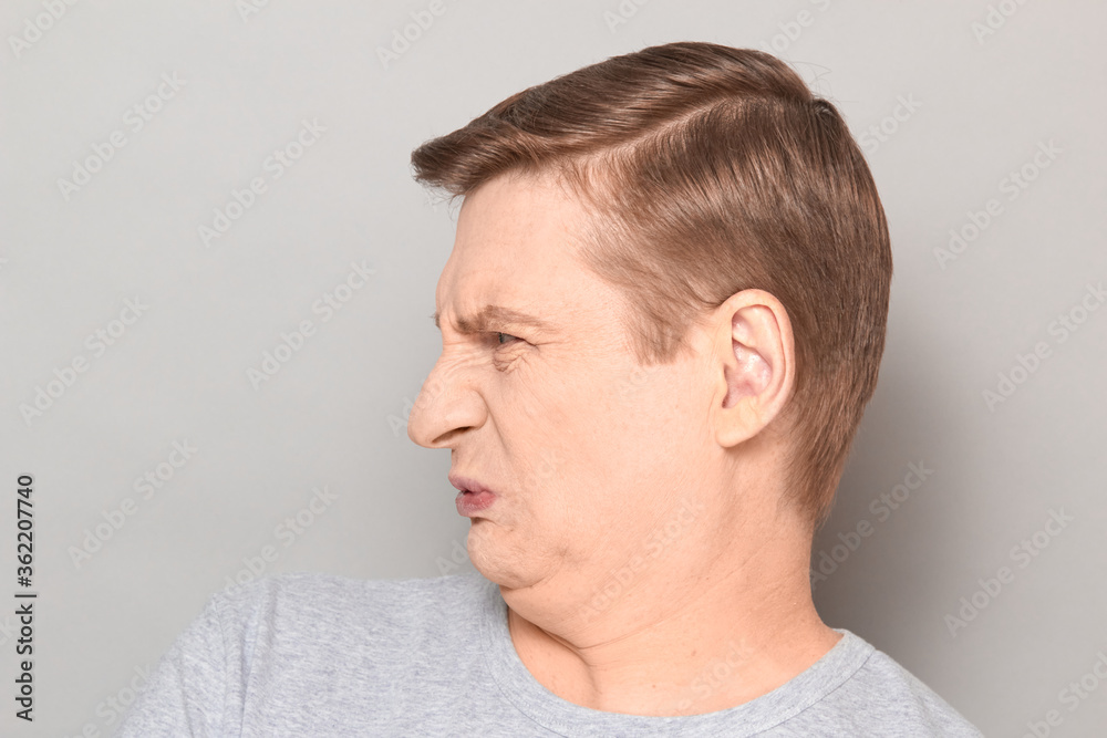 Obraz premium Portrait of funny man grimacing from disgust and squeamishness