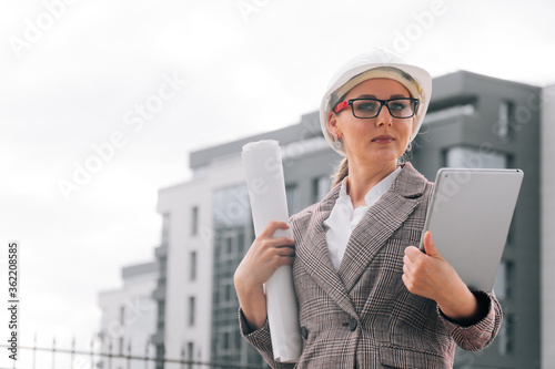 The concept of construction according to the drawings. Sketches in a tube in the hands of a young builder designer photo