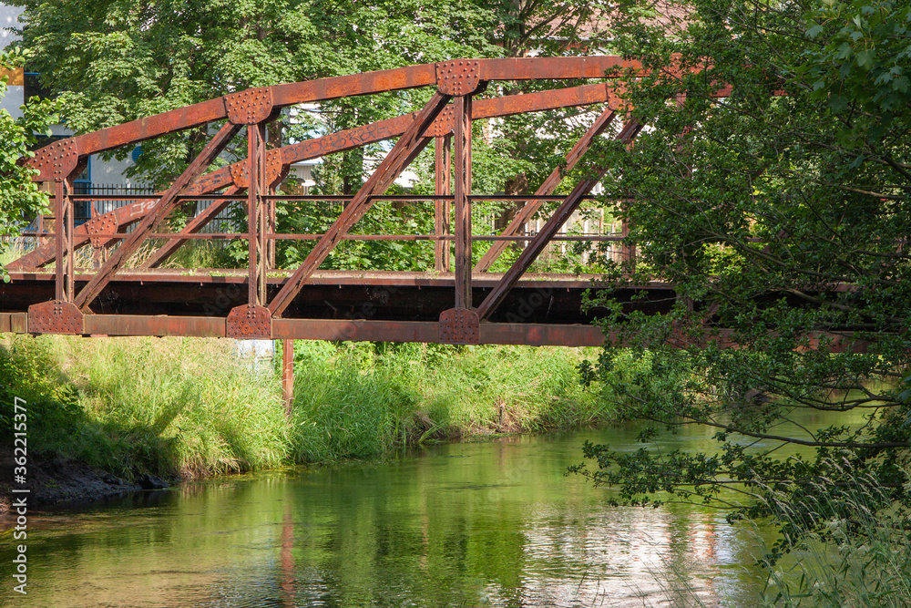 an old, rusty bridge over a river, closed for cars an old, rusty bridge over a river, closed for cars