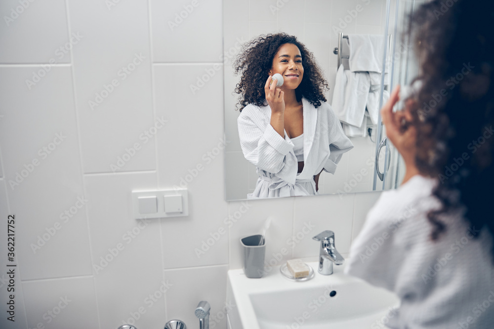 Smiling dark-haired lady using a silicone brush Smiling dark-haired lady using a silicone brush