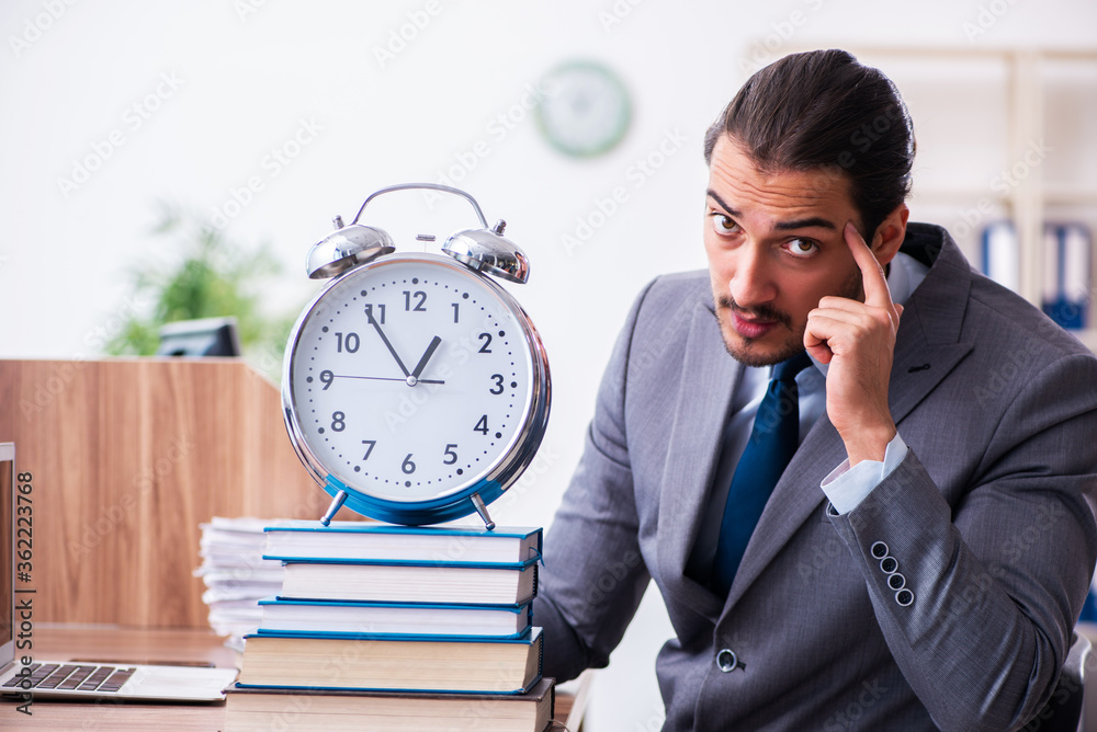 Young male businessman reading books at workplace Young male businessman reading books at workplace