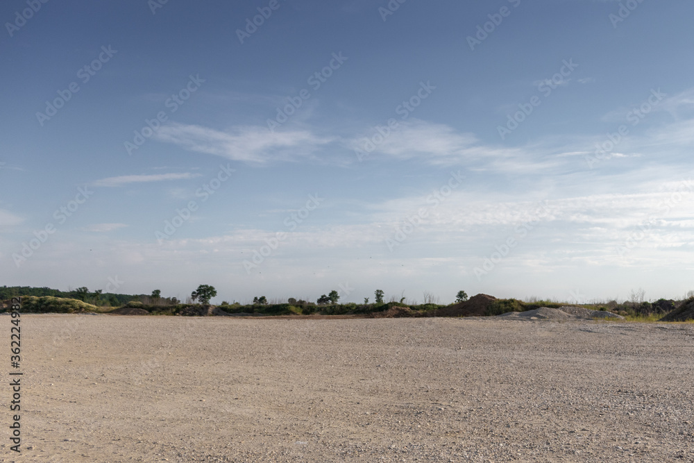 Large gravel background site with cloudy sky
