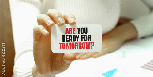 Businesswoman holding a card with text ARE YOU READY FOR TOMORROW