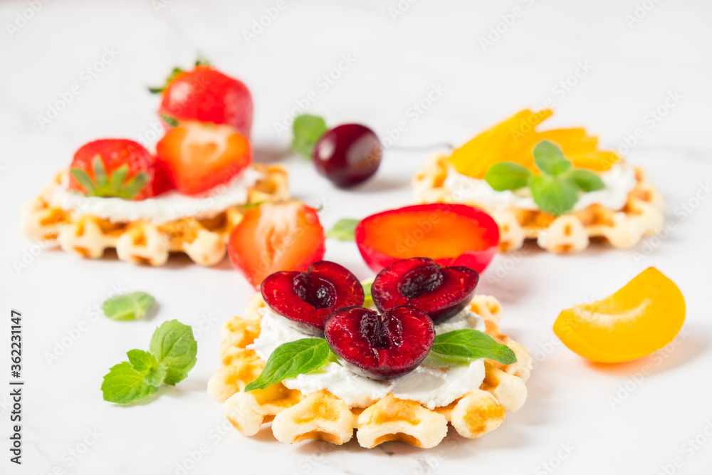 Top view of traditional Belgian waffles with soft cheese, fruits and berries with copy space. Top view of traditional Belgian waffles with soft cheese, fruits and berries with copy space.