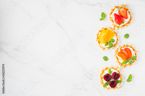 Top view of traditional Belgian waffles with soft cheese, fruits and berries with copy space.