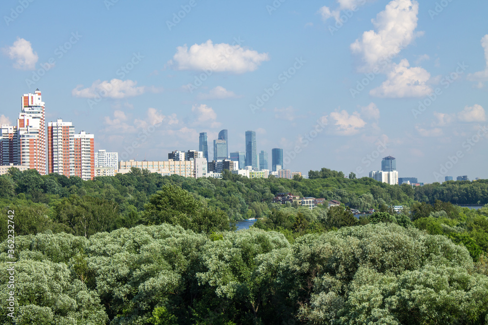 Panoramic view of modern residential buildings in Moscow Russia on a clear Sunny summer day with green trees a copy space