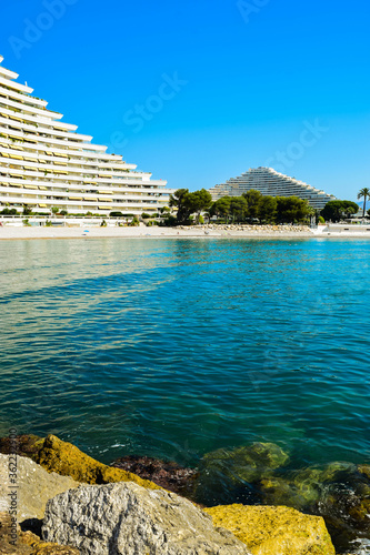 Landscape of the beautiful pebble beach of the Cote d'Azur at sunny morning. Beach holidays by the calm Mediterranean Sea. France.