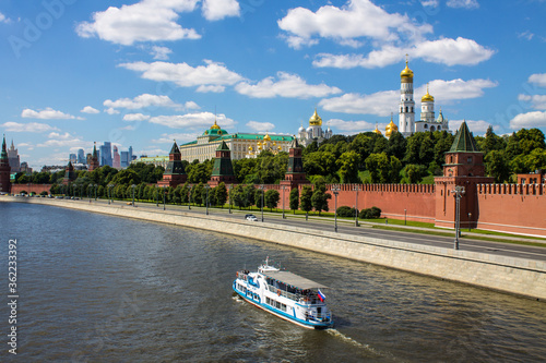 Panoramic view of the red brick Kremlin wall and the white stone assumption Cathedral with Golden domes and the Moscow river on a Sunny summer day in Moscow Russia