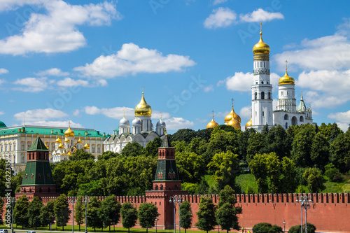 Panoramic view of the historical center of Moscow Russia with the red brick Kremlin wall and the assumption Cathedral with Golden domes against a bright blue sky and space for copying