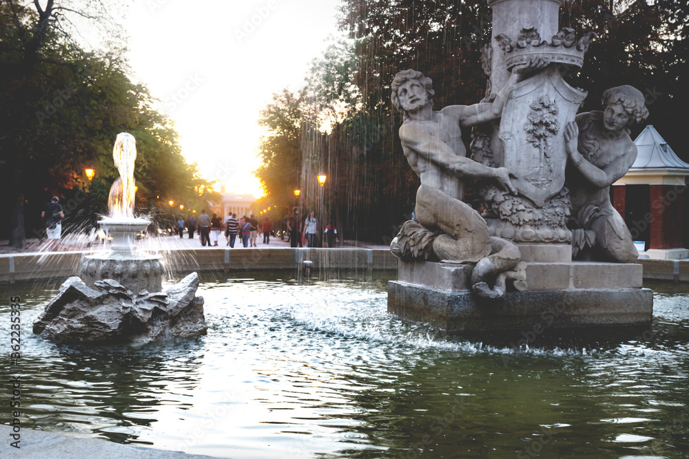 Fountain Alcachofa with sunset in background along path in park Retiro, Madrid, Spain