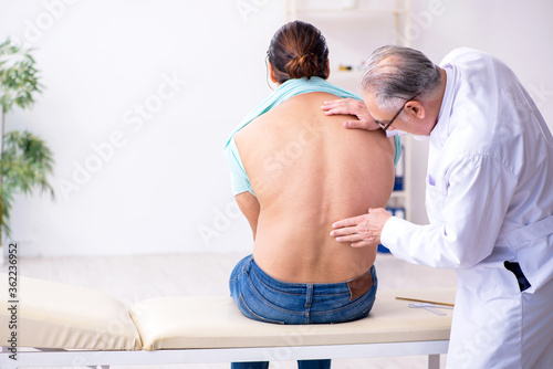 Young back injured man visiting experienced male doctor