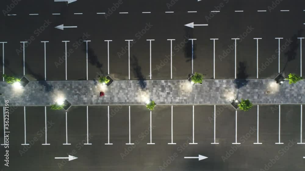 The aerial view on the man walking along the empty path