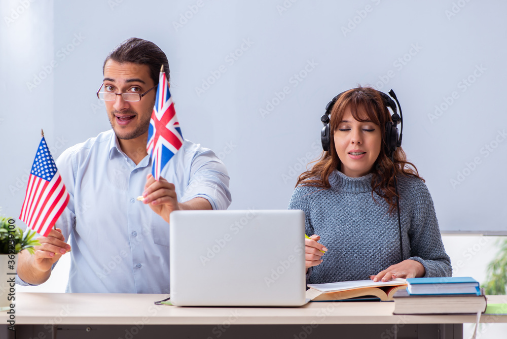 Young female student and male english teacher in the classroom Young female student and male english teacher in the classroom