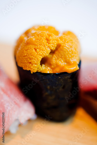 orange raw sea urchin uni wrapped with seafood nori sushi close up