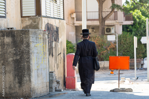 jew with long black suit and hat walking down the street © Sabrina Umansky