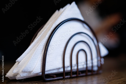 iron black stand with white napkins stands on the table, institution, cafe, serving details, rest, cleanliness, etiquette