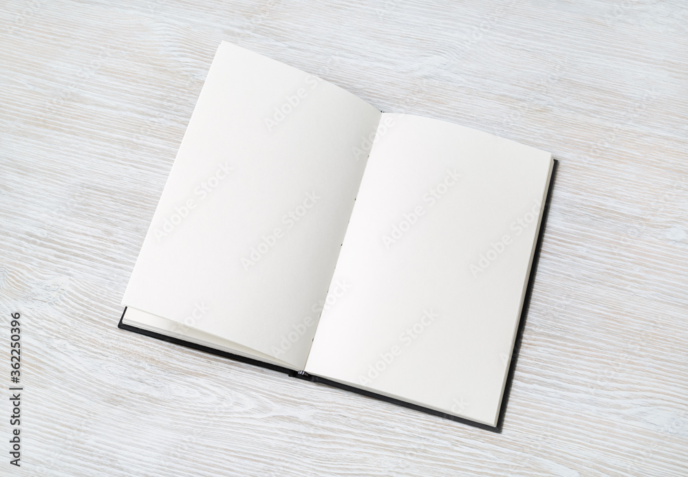 Opened booklet with blank white pages on light wooden background. Space for text. Opened booklet with blank white pages on light wooden background. Space for text.
