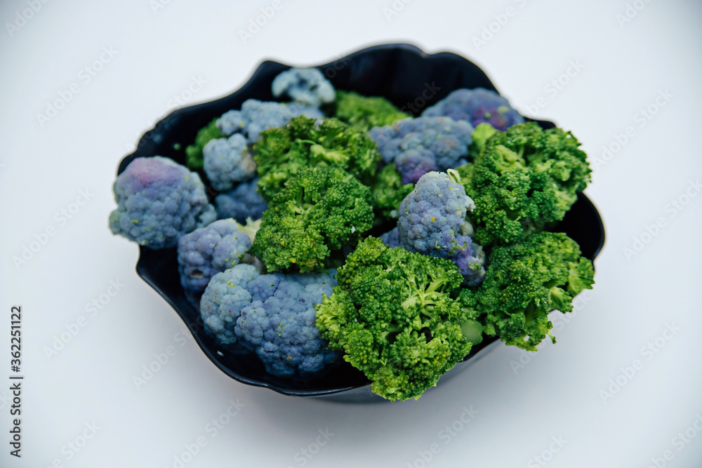 cauliflower lies in a black plate isolated on a white background. cauliflower lies in a black plate isolated on a white background.