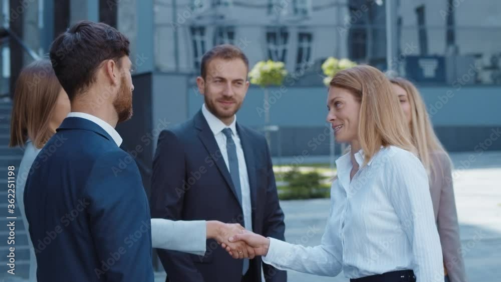 Teambuilding. Success at work. Friendly female boss shaking hands with her staff workers in corporate yard. Happy male and female colleagues. Career. Professionals. Teambuilding. Success at work. Friendly female boss shaking hands with her staff workers in corporate yard. Happy male and female colleagues. Career. Professionals.