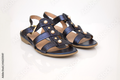 Blue leather women's sandals isolated on a white milk background. Mirror reflection