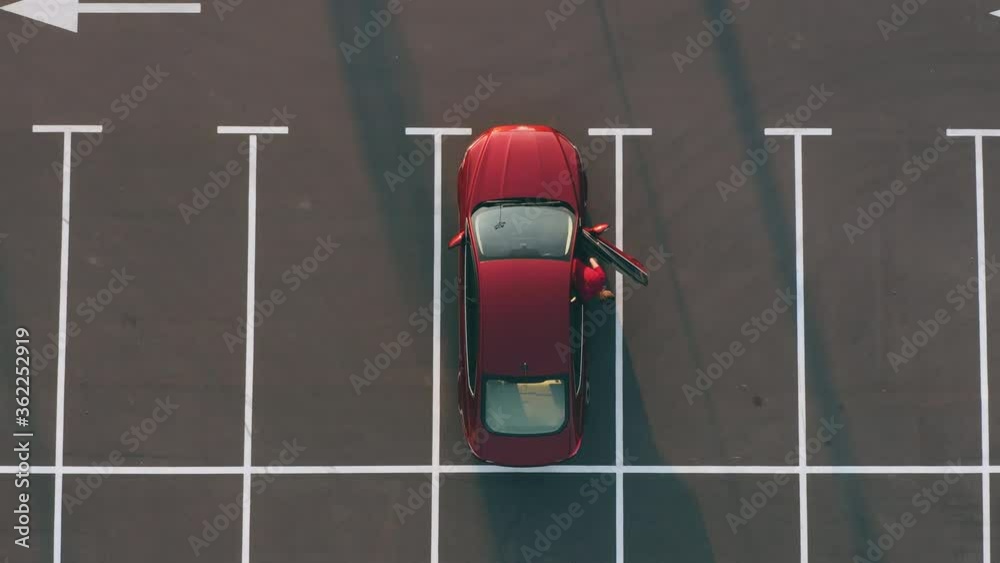 The man gets out of the car on the empty parking lot