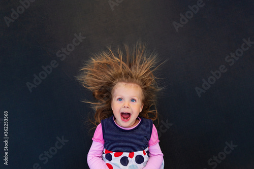 Portrait of a girl with electrified hair on a black background