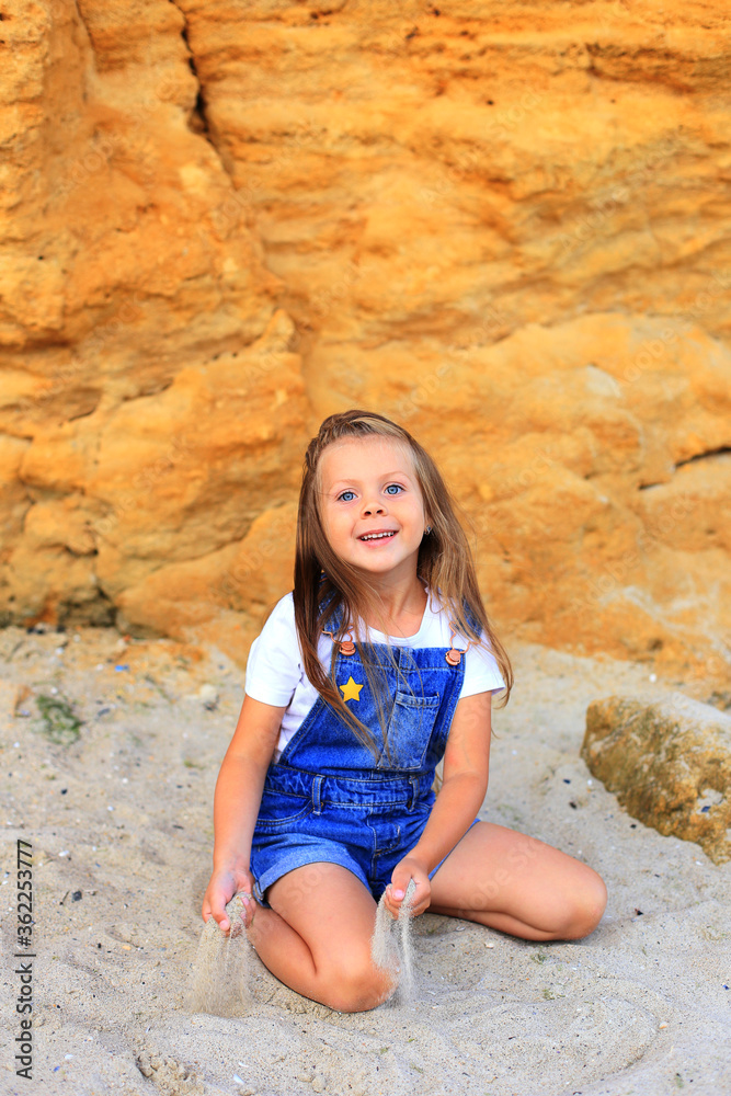 A child on the stones near the sea in summer A child on the stones near the sea in summer