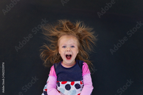 Portrait of a girl with electrified hair on a black background