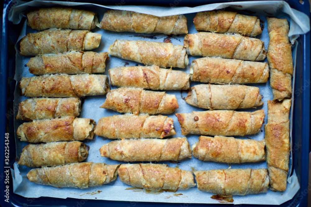 Blurry view of home made spring rolls. It contains lentils, poppy, minced meat, butter and spices. This food is quite common in Middle East, South and Central Asian cuisine.