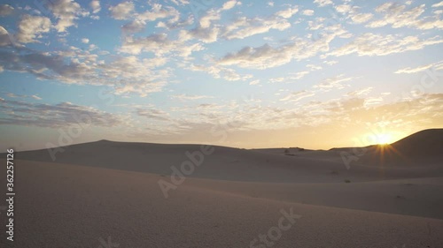 Timelapse of a sunrise over desert sand dunes photo