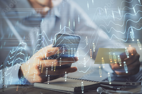 Double exposure of man s hands holding and using a phone and financial graph drawing. Analysis concept.