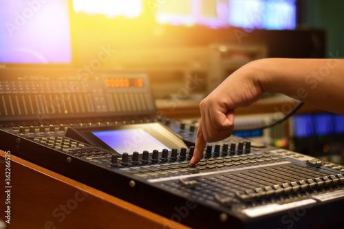 hand moving sliders on audio mixing board