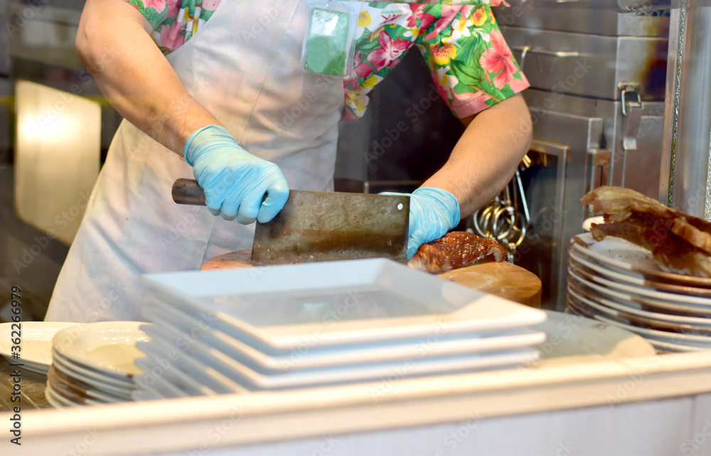 Street food merchant slicing duck meat using large knife for sale in the market during Songkran Festival of Thailand. Street food merchant slicing duck meat using large knife for sale in the market during Songkran Festival of Thailand.